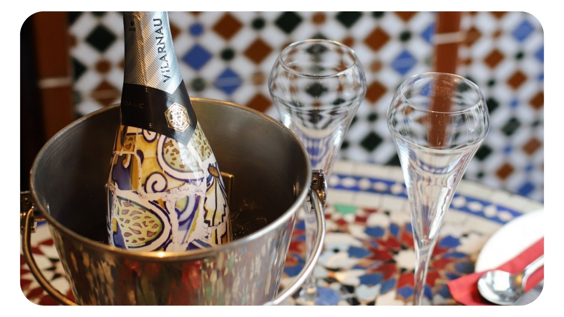 Shot of cava bottle in ice bucket with two glasses beside it in Cafe Andaluz