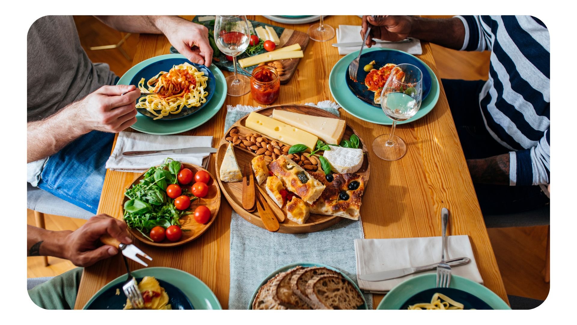 Overhead shot of people eating in a restaurant with various Italian dishes laid on the table