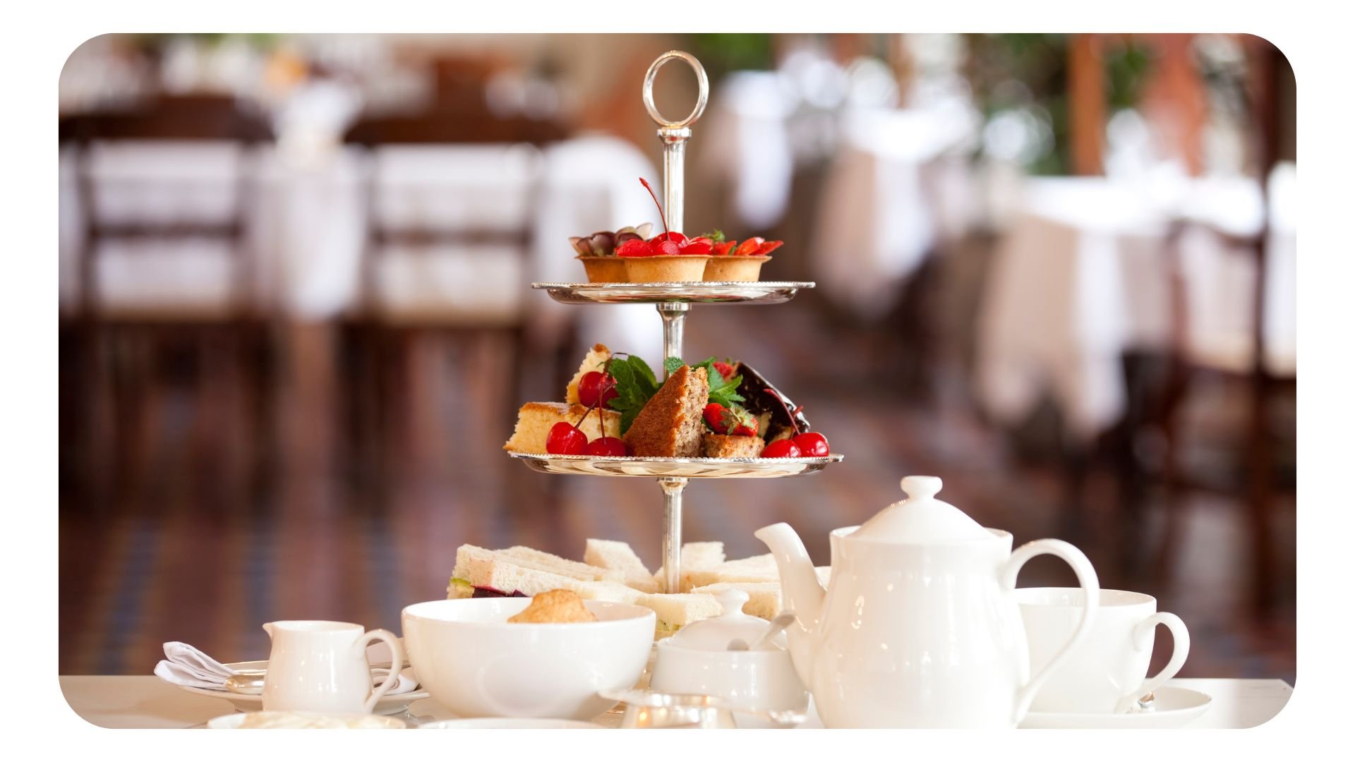 Photo of afternoon tea setting with teapots and cakes