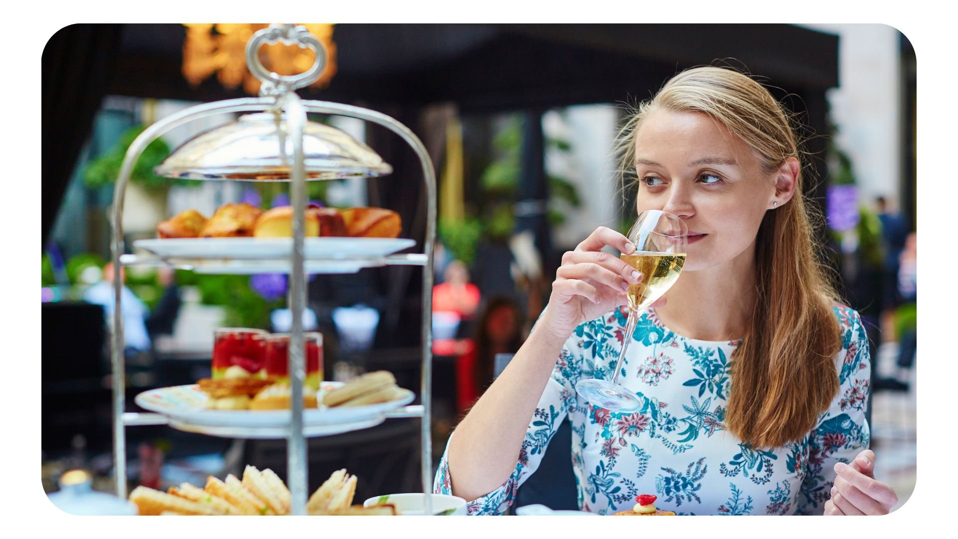 Woman drinking prosecco with afternoon tea