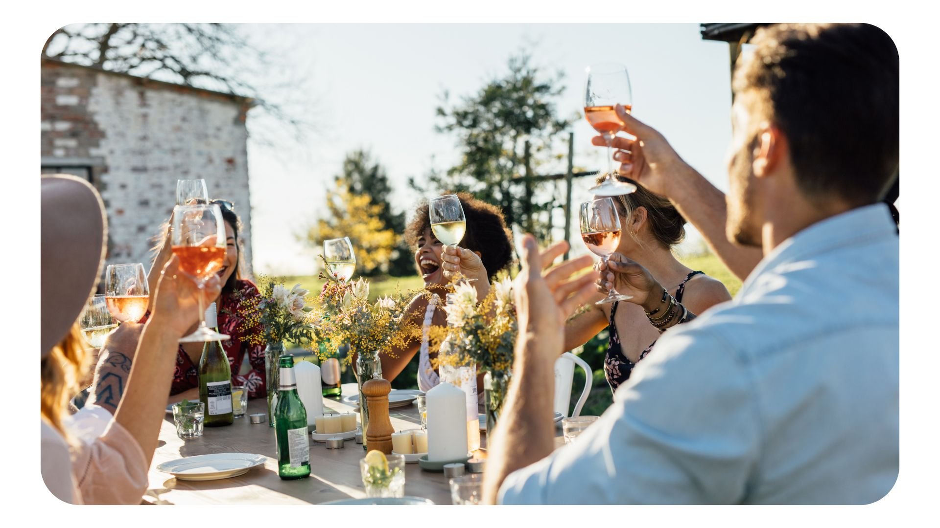 Photo of restaurant customers enjoying food and wine in a sunny outside space during summer