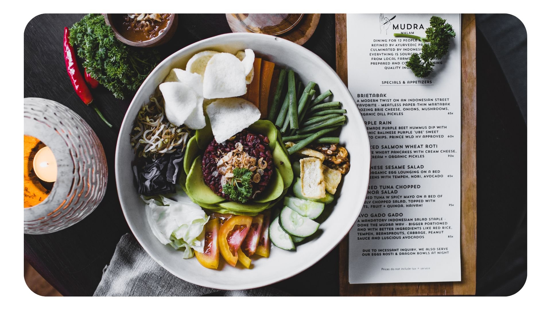 Photograph of a plate of restaurant food next to a menu with a summer theme