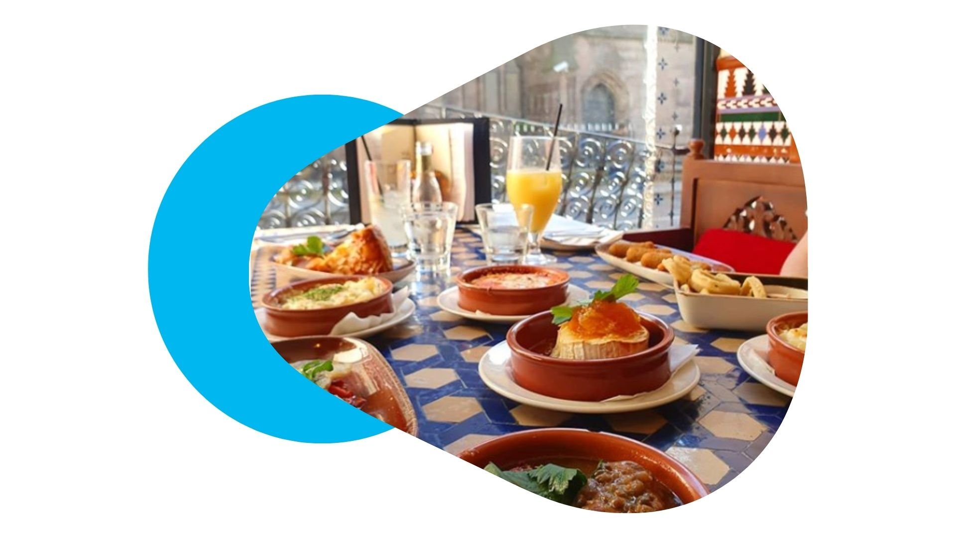 Shot of Cafe Andaluz interior table setup by window with sun shining through and tapas dishes on display