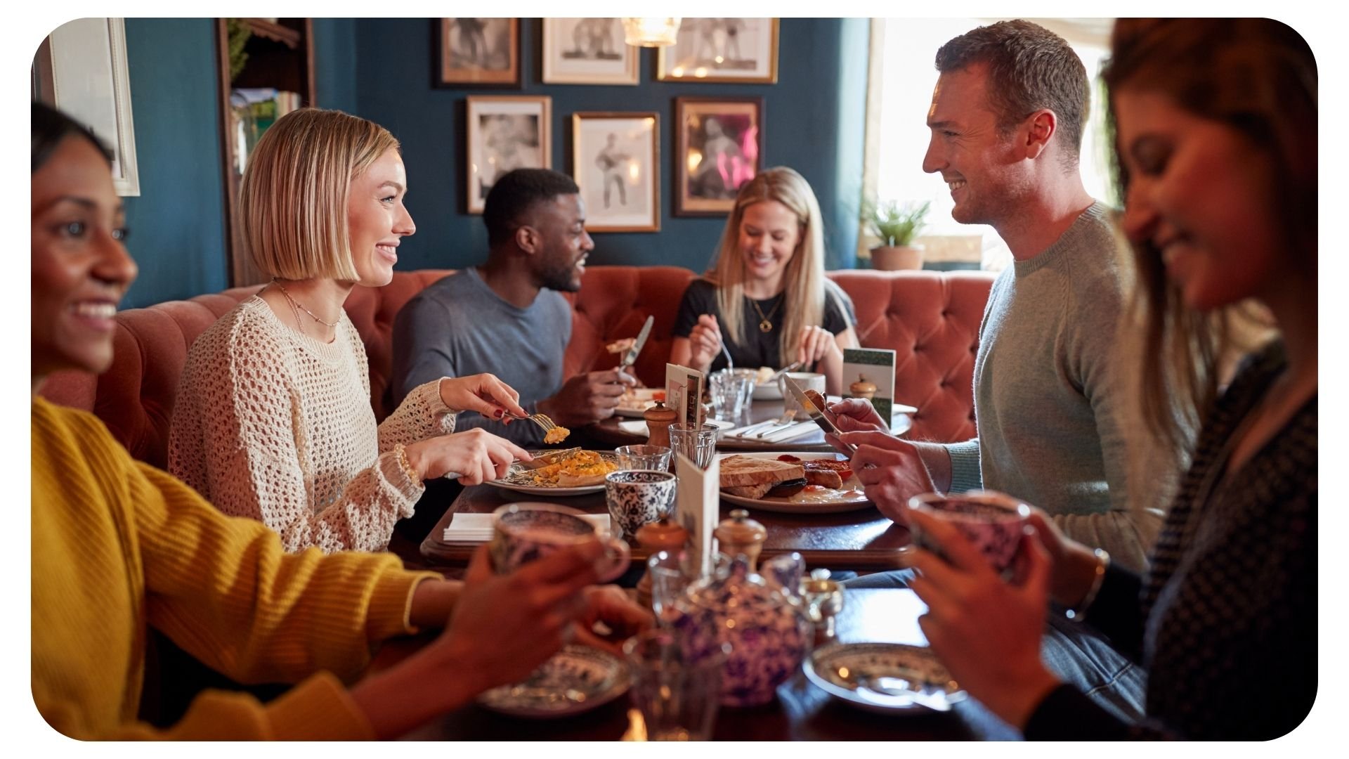 Photo of customers smiling in a pub while using their smartphones-1