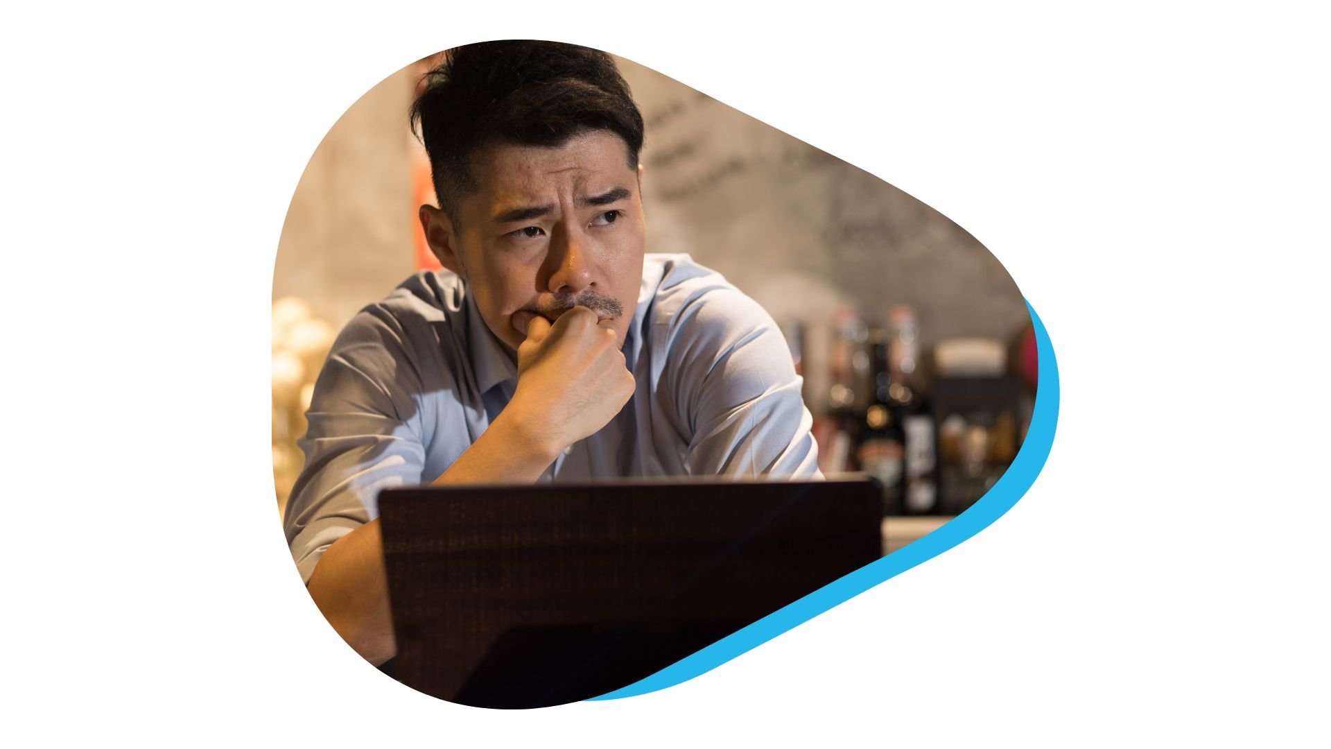 Apprehensive looking restaurant manager working on laptop