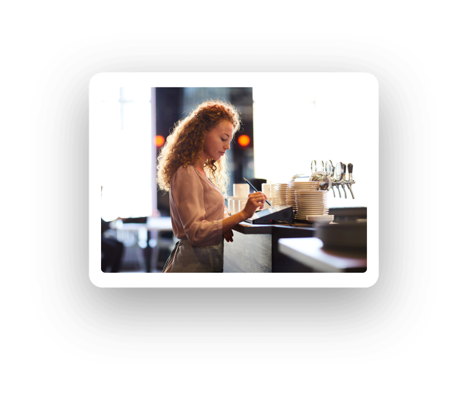 Restaurant staff member using epos behind bar