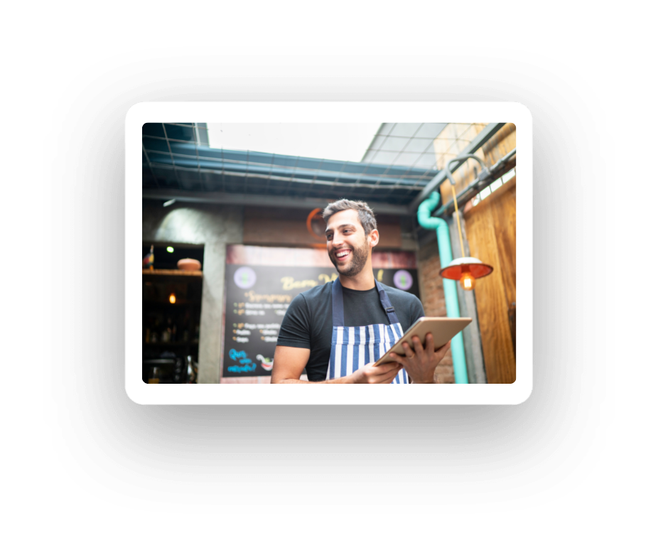 Restaurant staff member using using tablet next to table